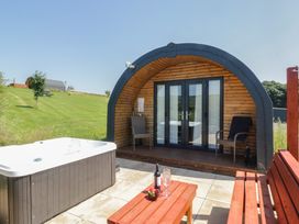 An outdoor area with a hot tub and wooden cabin at Rowan in Ulverston