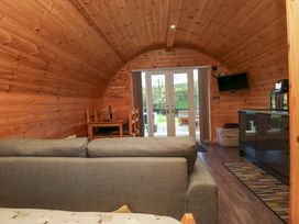 A living room with a sofa, table, and television at Cherry in Ulverston