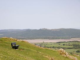 A bench on a hillside overlooking fields and water at Cherry in Ulverston