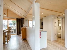 A kitchen with dining area and access to the bathroom at Lodge 14 Corfe Castle