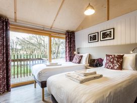 A bedroom with two beds and a view of trees at Lodge 14 in Corfe Castle