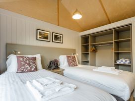A bedroom with two single beds and a wardrobe at Lodge 14 Corfe Castle