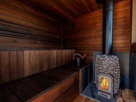 A sauna with a wooden bench and a wood stove at Lodge 15 in Corfe Castle