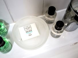A soap dish with sea kelp soap and bottles in a bathroom at Lodge 17 in Corfe Castle