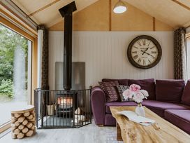A living room with a purple sofa and a fireplace at Lodge 19 in Corfe Castle