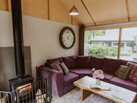 A living room with a purple sofa and wood stove at Lodge 19 in Corfe Castle