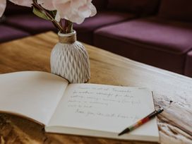 A notebook and a flower vase on a table at Lodge 19 in Corfe Castle