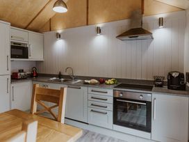 A kitchen with cabinet, sink, and appliances at Lodge 19 in Corfe Castle