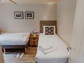 A bedroom with two beds and a nightstand at Lodge 19 in Corfe Castle