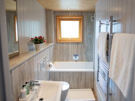 A bathroom with a bathtub and sink at Lodge 19 in Corfe Castle