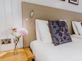 A bedroom with a bedside table and a flower vase at Lodge 19 in Corfe Castle
