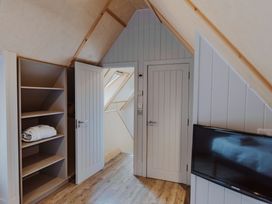 A bedroom with shelves and a television at Lodge 19 in Corfe Castle