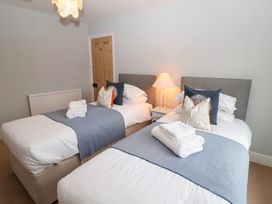 A bedroom with two beds, nightstand, and lamp at Elkhorn in Southwold