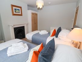 A bedroom with three beds and a lamp at Elkhorn in Southwold