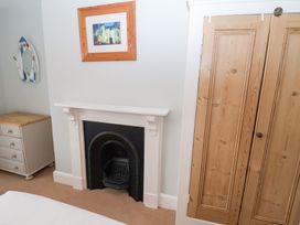A bedroom with a fireplace and wardrobe at Elkhorn in Southwold