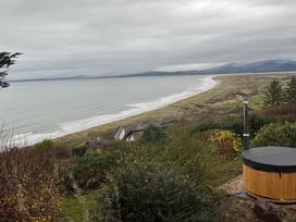 View of the beach and sea with a hot tub in the foreground at Sibrwd Y Mor in Harlech