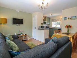 A living room with a television and dining area at 14 The Dell Mundesley