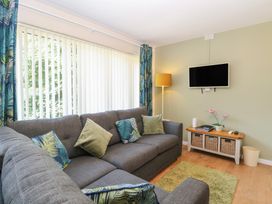 A living room with a sofa and television at 14 The Dell Mundesley