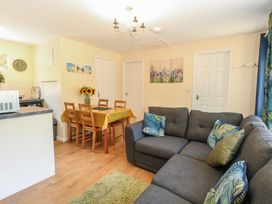 A living room with a sofa and dining area at 14 The Dell Mundesley