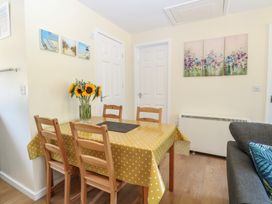A dining room with a table and flowers at 14 The Dell Mundesley