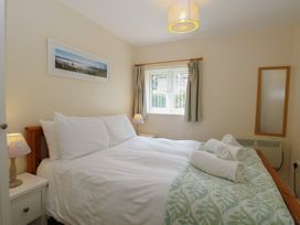 A bedroom with a bed and window at 14 The Dell Mundesley