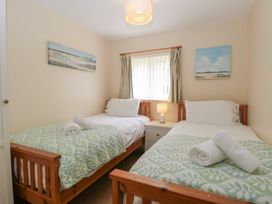 A bedroom with two single beds and a nightstand at 14 The Dell Mundesley