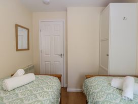 A bedroom with twin beds and a mirror at 14 The Dell in Mundesley