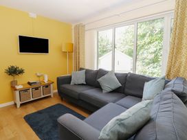 A living room with a sofa and television at 15 The Dell in Mundesley