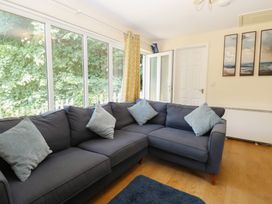 A living room with a sofa and door at 15 The Dell Mundesley
