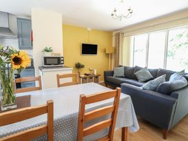 A living room with a dining table and sofa at 15 The Dell Mundesley