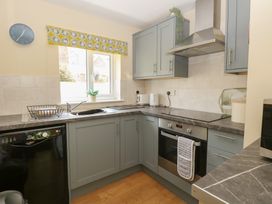 A kitchen with various appliances and cabinets at 15 The Dell in Mundesley