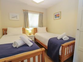 A bedroom with two single beds and a nightstand at 15 The Dell Mundesley