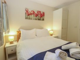 A bedroom with a bed and bedside tables at 15 The Dell in Mundesley