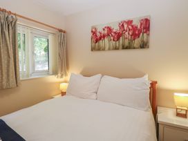 A bedroom with a bed and flowers on the wall at 15 The Dell Mundesley