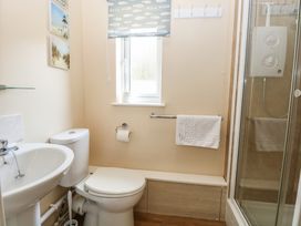 A bathroom with a sink, toilet, and shower at 15 The Dell Mundesley