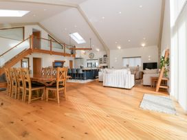 An open-plan living area with a dining table and kitchen at Bilsham Meadows in Aust