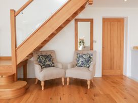 A sitting room with two chairs and a staircase at Bilsham Meadows in Aust