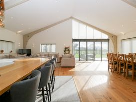 A living room with a dining area and sliding doors at Bilsham Meadows in Aust