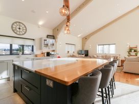 A kitchen with an island and stools at Bilsham Meadows in Aust