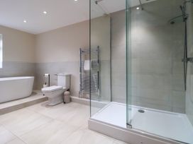 A bathroom with a bathtub toilet shower and towel rack at Orme Villa in Llandudno