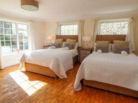 A bedroom with two beds and bedside tables with lamps at Orme Villa in Llandudno