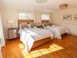 A bedroom with two beds side by side with pillows and lamps on bedside tables at Orme Villa in Llandudno