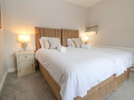 A bedroom with two beds joined together bedside tables and lamps at Orme Villa in Llandudno