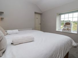 A bedroom with two beds with white linens a window with a vanity mirror and a door at Orme Villa in Llandudno