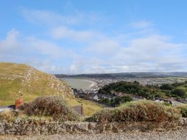 A hillside view overlooking a bay with town buildings and hills under a blue sky at Orme Villa in Llandudno