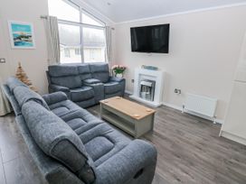 A living room with a sofa and coffee table at Dono's Lodge, Stepaside near Kilgetty, Heritage Park