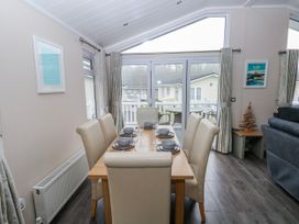 A dining room with a table and chairs at Dono's Lodge, Stepaside near Kilgetty, Heritage Park