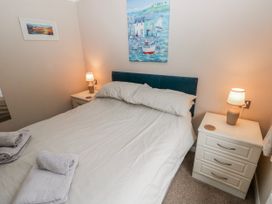 A bedroom with a bed and bedside tables at Dono's Lodge, Stepaside near Kilgetty, Heritage Park