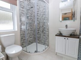A bathroom with a shower, toilet, and sink at Dono's Lodge Stepaside near Kilgetty, Heritage Park
