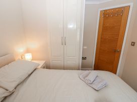 A bedroom with bed and wardrobe at Dono's Lodge, Stepaside near Kilgetty, Heritage Park